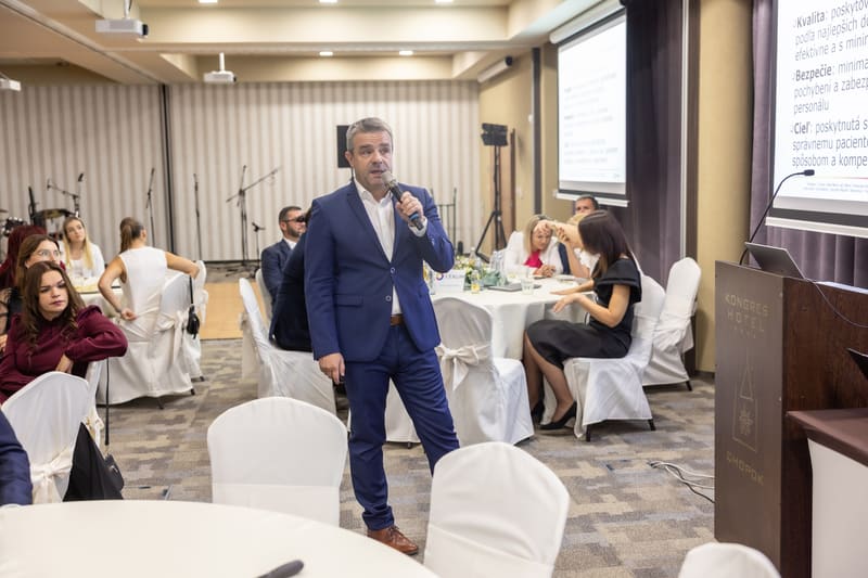 Rečník s mikrofónom na firemnej konferencii, business fotografia