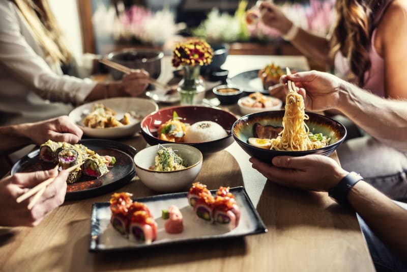 Skupina ľudí pri ázijských jedlách, obsah pre gastro marketing