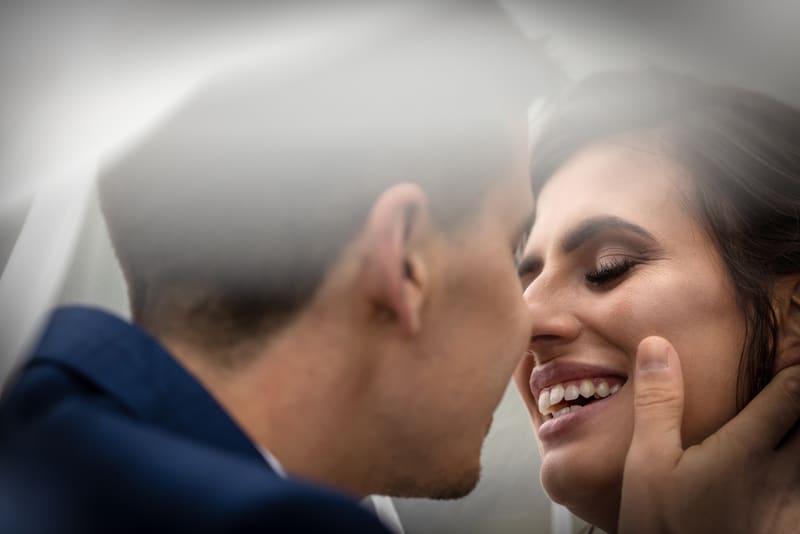Bozk novomanželov pod závojom, svadobná fotografia